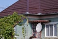 Television satellite receiver antenna on a house in a village in rural Romania