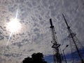 television station receiver and transmitter tower with a background of cumulus clouds Royalty Free Stock Photo