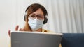telework. woman in a medical mask works remotely in a digital tablet wearing a medical protective mask. office home