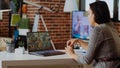 Teleworking team leader in cozy apartment discussing with coworkers in videocall