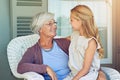 Tell grandma everything. a young girl sitting outside with her grandmother.