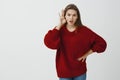 Tell me everything he said to you. Indoor shot of shocked and intense charming female coworker in loose red sweater