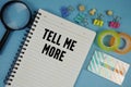 Tell Me More text with magnifying glass on blue background Royalty Free Stock Photo