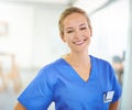 Tell me where it hurts. Portrait of a confident young doctor wearing blue scrubs. Royalty Free Stock Photo