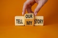 Tell our or my story symbol. Businessman hand turns wooden cubes and changes the words Tell my story to tell our story. Beautiful Royalty Free Stock Photo