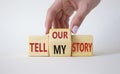 Tell our or my story symbol. Businessman hand turns wooden cubes and changes the words Tell my story to tell our story. Beautiful Royalty Free Stock Photo