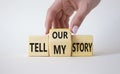 Tell our or my story symbol. Businessman hand turns wooden cubes and changes the words Tell my story to tell our story. Beautiful Royalty Free Stock Photo