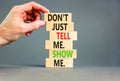 Tell or show symbol. Concept words Do not just tell me, show me on wooden blocks. Beautiful grey table grey background.