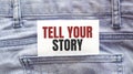 TELL YOUR STORY words on a white paper stuck out from jeans pocket. Business concept