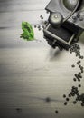 Telling story from the past - grinding roasted beans of coffee with old vintage retro grinder with ground coffee and green leaf Royalty Free Stock Photo