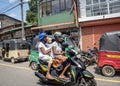 TELULLA, SRI LANKA - 13 NOVEMBER, 2019: Slightly blurred figures of a mother, daughter and grandmother on a motorcycle ride fast