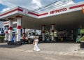 TELULLA, SRI LANKA - 13 NOVEMBER, 2019: A young woman in national Sari dress speaks on a cell phone as she passes a gas station