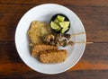 Tempe and Sate Ayam, Tempeh and chicken satay, with sliced kaffir limes on white plate