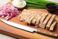 tempeh slices on a bamboo board, knife nearby