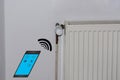 Temperature adjustment of a radiator via smartphone. Royalty Free Stock Photo