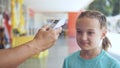 Temperature check at a supermarket of little girl, grocery store with thermal imaging camera installed. Coronavirus Royalty Free Stock Photo