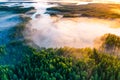 Temperature contrast concept. Sunny morning, aerial landscape. Thick fog covers green forest and lakes