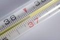 temperature 37 on a thermometer on a white background, fever Royalty Free Stock Photo