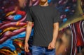 Template of blank t-shirt on a young guy in blue jeans on a background of a wall with graffiti, front view