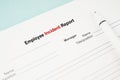The Template of an Employee incident report form document and and pen on blue background Royalty Free Stock Photo