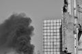 Template in the form of a building wall against the sky and thick black smoke. Black and white Royalty Free Stock Photo