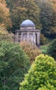 Temple of Apollo located amidst trees and shrubs overlooking the lake at Stourhead National Trust property. Wiltshire UK