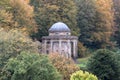 Temple of Apollo located amidst trees and shrubs overlooking the lake at Stourhead National Trust property. Wiltshire UK