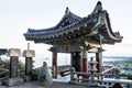 Temple bell house with view over coastline at Sanbanggulsa temple, Sanbang-ro, Jeju Island, South Korea