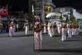 A Temple Custodian surrounded by Spear Bearers parades along a street at Kandy in Sri Lanka during the Esala Perahera