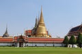 Temple of Emerald Buddha Wat Phra Kaew in Bangkok, Thailand with tree branches front isolated on blue sky background closeup. Royalty Free Stock Photo