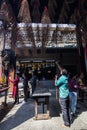 SAIGON, VIETNAM - FEB 13, 2018 - A temple guardian bring spiral incense sticks hanging from the ceiling in Thien Hau Pagoda, the C