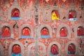 The Temple wall contains hundreds of Buddha statue`s in alcove`s the wal Royalty Free Stock Photo