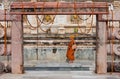 Temple wall with walking monk in yellow buddhist dress