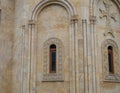 Temple walls with windows. Yellow-brown material. Church cladding. Background from stone tiles