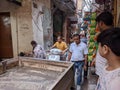 a tempo is blocking the way of people in a narrow lane of an old town of Delhi