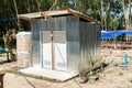 A temporary toilet with a water tank at the construction site made with the metal sheet and modern bathroom sanitary.