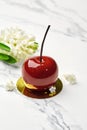 Tempting cherry-shaped pastry with white flowers on marble Royalty Free Stock Photo
