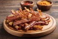 Stack of fried bacon strips on the wooden plate Royalty Free Stock Photo