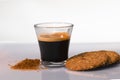 a tempting espresso surrounded by cookies and brown sugar on a glass table concept.