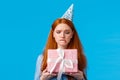 Tempting moment of unwrapping gift. Cute glamour redhead teenage girl biting lip eager open cute birthday present