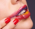 Tempting tones. a woman smearing the multicolored lipstick off of her lips.