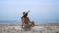 Tempting woman sitting beach wearing swimsuit in front beautiful ocean waves. Royalty Free Stock Photo