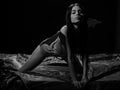 Temptress concept. Lady sexi dressed as demon, devil, black background. Demon girl crawl on silk sheets. Woman on Royalty Free Stock Photo