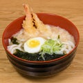 Tempura udon with fried shrimps, boiled egg, green algae, leeks, tipical japanese noodles