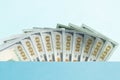 Ten bills of 100 dollar on the light blue background. Conceptual photo, minimalistic design