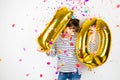 Ten birthday party girl with golden balloons and confetti