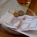 Ten Euro Bill with Coins on Plate on Wooden Table in Restaurant. Royalty Free Stock Photo