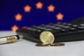 Ten Germany euro cent on obverse and two coin of two euro cent on white floor with black calculator and pencil, Euro flag. Royalty Free Stock Photo