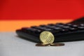 Ten Germany euro cent on obverse and two coin of two euro cent on white floor with black calculator, Red and yellow background. Royalty Free Stock Photo