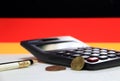 Ten Germany euro cent on reverse and two coin of two euro cent on white floor with black calculator and pencil, Germany flag. Royalty Free Stock Photo